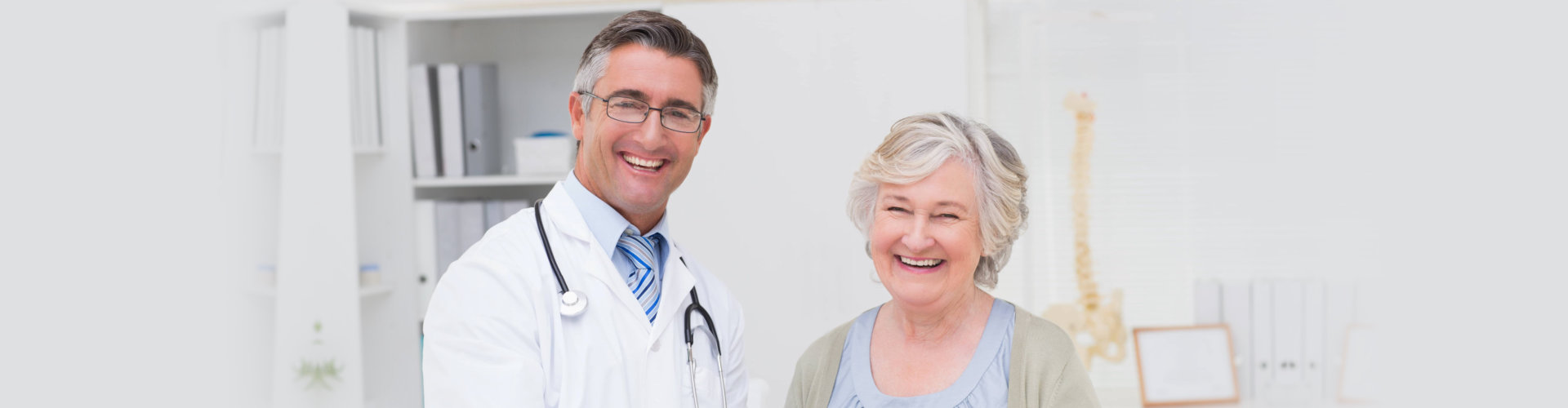 smiling doctor with his old woman patient at the office