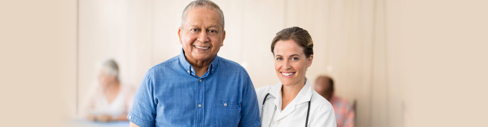 smiling female doctor wearing stethoscope with her old man patient wearing denim polo